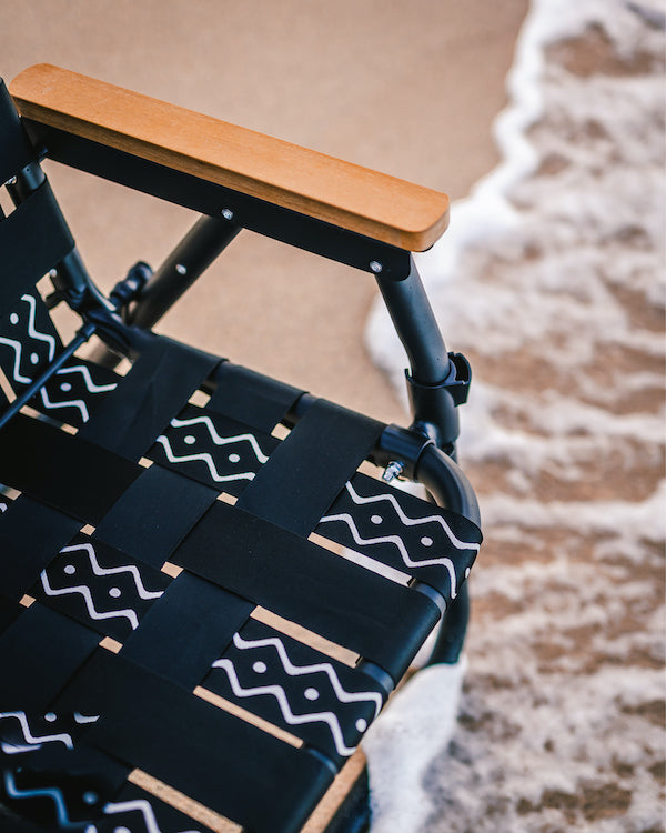 a Parkit Voyager camping chair being a beach chair with the photo showing the ocean eaves lapping up on the chairs feet.