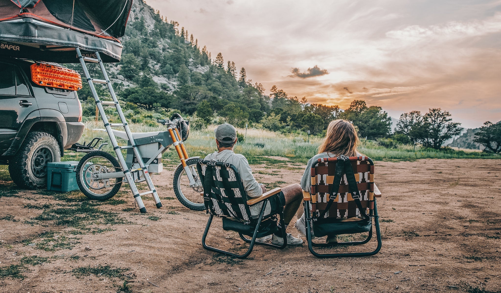 A couple sitting in their Voyager Outdoor Chairs while watching the sun set in the mountains of Colorado.